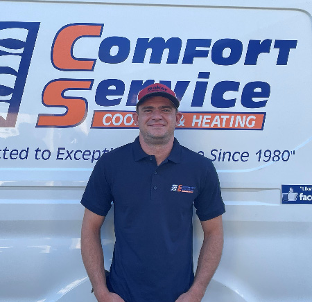 Alex Shneider standing in front of a white van with the blue and orange Comfort Service logo.