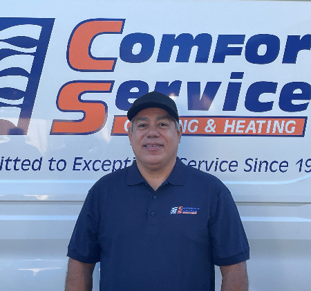 Jose Abrego standing in front of a white van with the blue and orange Comfort Service logo.